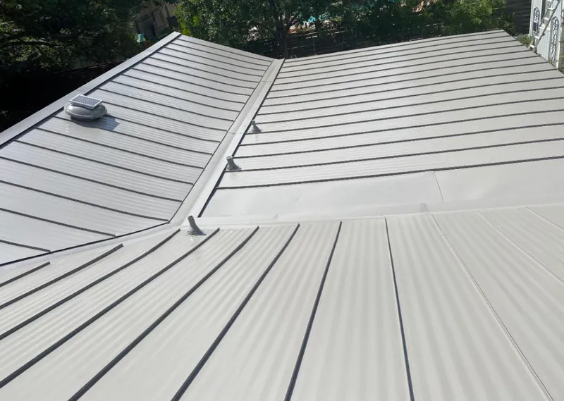 Solar attic fan installed on a metal roof for Roof Ventilation in Mineola